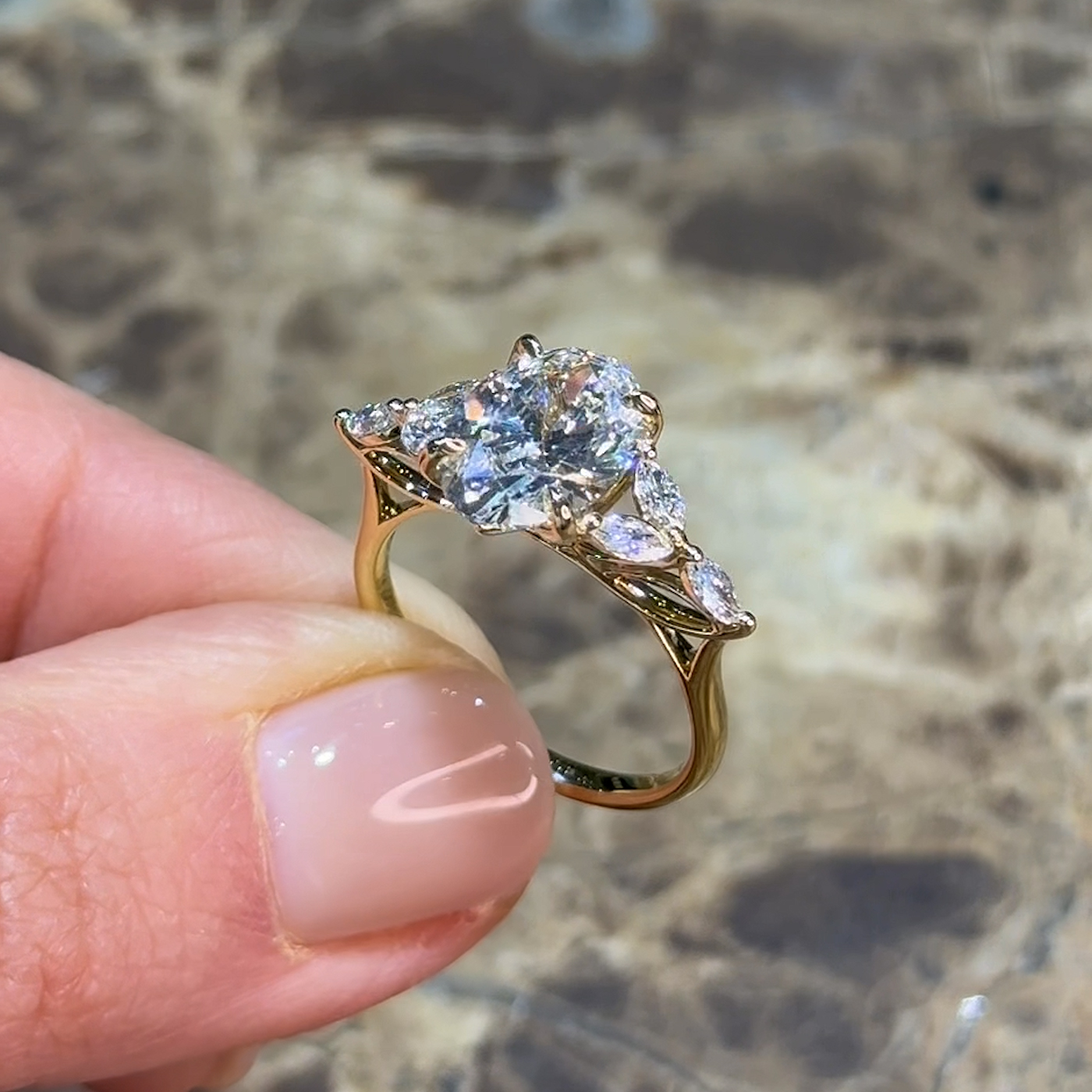 18k yellow gold oval lab-grown diamond engagement ring with marquise side stones and floral gallery