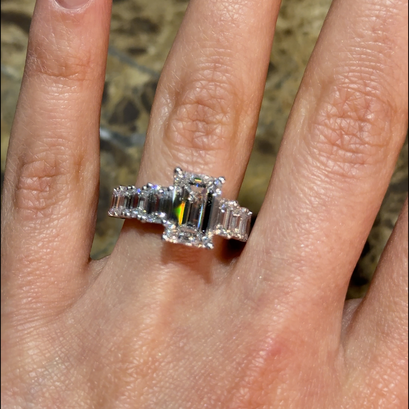 18k white gold emerald cut lab-grown diamond ring with ¾ baguette cut graduating diamonds in shared prong-set Photos & images
